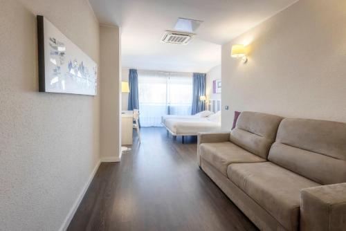a living room with a couch and a bedroom at Hotel La Palma de Llanes in Llanes