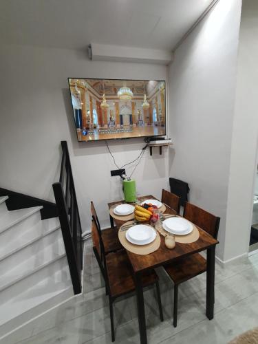 - une table à manger avec des chaises et des assiettes dans l'établissement Duplex avec mezzanine au cœur de la ville de nancy, à Nancy