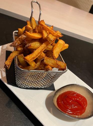 a container of french fries and a bowl of ketchup at Sans Souci Bed and Breakfast Luxe Heated Pool and Restaurant in Luzillé