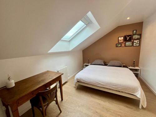 una camera con letto, scrivania e finestra di Jolie petite maison ad Amiens
