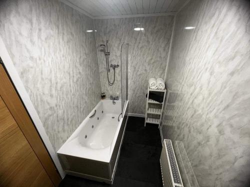 a bathroom with a bath tub and a shower at Hillview Portree Isle of Skye Self Catering House in Portree