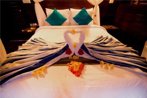 a white bed with two swans forming a heart at Sunset Coin Lembongan in Nusa Lembongan