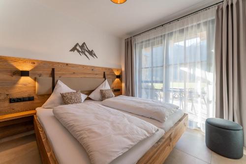 a bedroom with a large bed and a window at Chalet Charlotte in Niedernsill