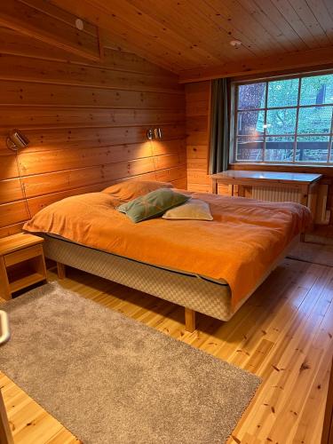 a bedroom with a bed in a wooden room at Saajopolku 4 in Saariselka