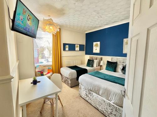 a hotel room with two beds and a tv at Summer Lane House-3 Bedrooms-Close to M1-Longer Stay-Free Parking in Barnsley