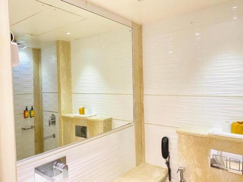 bagno con grande specchio e doccia di International Embassy Suites a Nuova Delhi