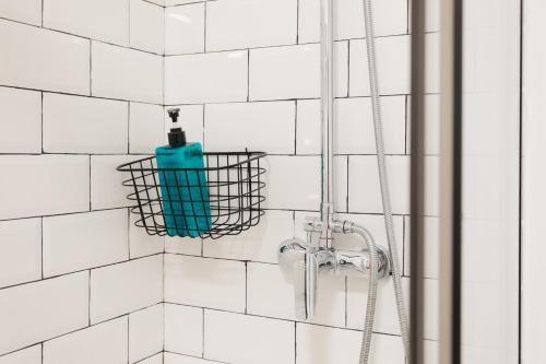 a shower with a green bottle in a basket on the wall at Amplio Apartamento Cerca Centro Histórico y Turia 5pax 2 Bath in Valencia