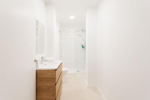 a white bathroom with a sink and a shower at Amplio Apartamento Cerca Centro Histórico y Turia 5pax 2 Bath in Valencia