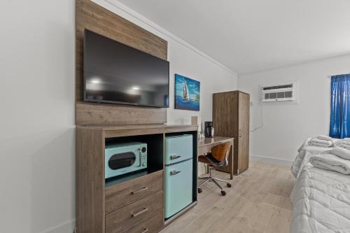 a bedroom with a tv and a desk with a microwave at Fin's Inn in Myrtle Beach