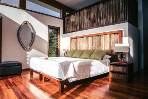 a bedroom with a large bed and a mirror at Green Fiji Plantation Villa in Taveuni 