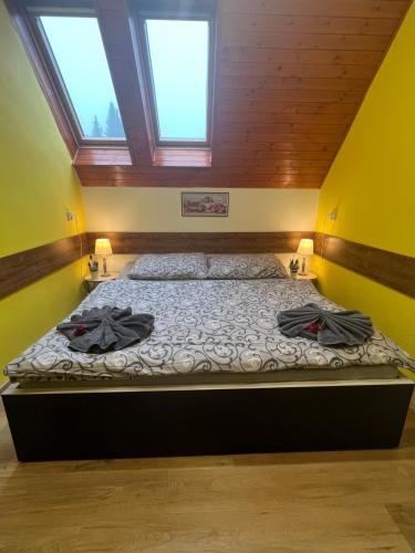 a large bed in a room with two windows at Penzion na Lůkách in Horní Bečva