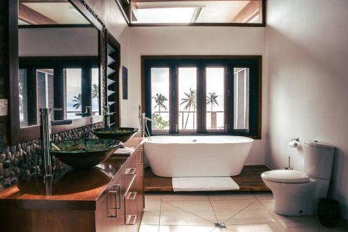 a bathroom with a large tub and a toilet at Green Fiji Plantation Villa in Taveuni 