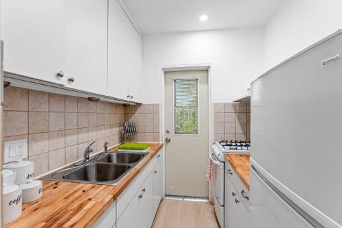 a kitchen with white cabinets and a sink at Beautiful Apt in Victoria Park (Las Olas Blvd) in Fort Lauderdale