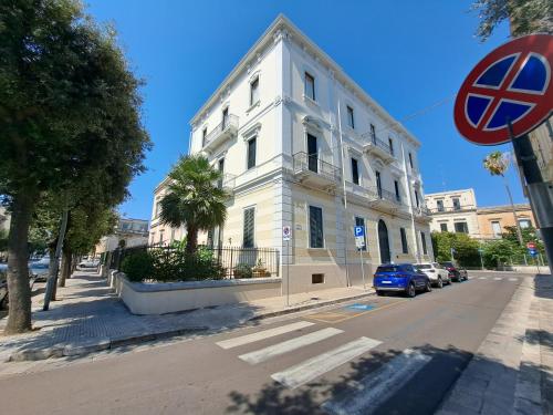 a white building on the side of a street at Palazzo Castellano in Lecce