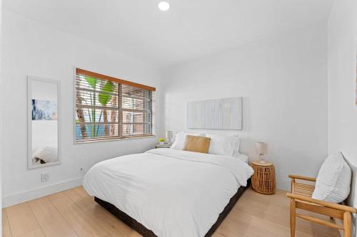 Un dormitorio blanco con una cama grande y una ventana en Beautiful Apt in Victoria Park (Las Olas Blvd), en Fort Lauderdale