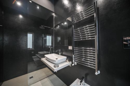 La salle de bains noire est pourvue d'un lavabo et d'un miroir. dans l'établissement 42 Zanardelli B&B, à Trani