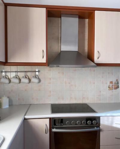 a kitchen with white cabinets and a stove top oven at Nereid Skyros House in Skiros