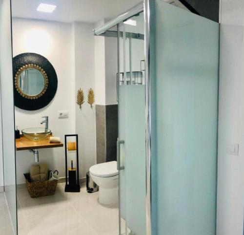 bagno con servizi igienici, lavandino e specchio di Luxury Bahia Sea Views By Deihu Experiences a Los Cristianos