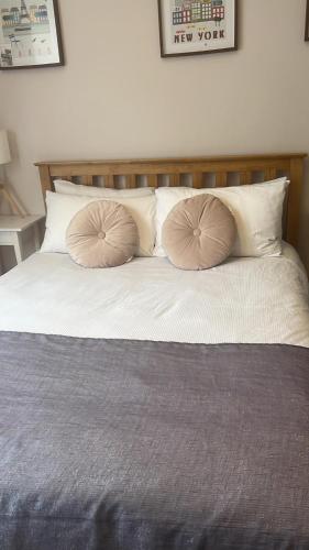 a bed with two pillows on top of it at 43A ground floor apartment in London