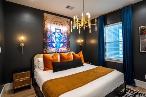 a bedroom with a large bed with a painting on the wall at The Green Haus: Luxxe Cabana Rooftop Retreat in Houston