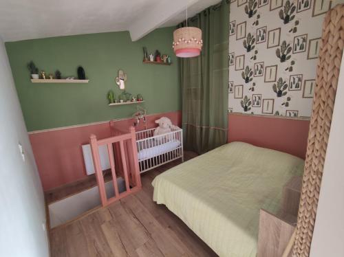 - une chambre pour enfants avec un lit bébé et des murs verts dans l'établissement Maison refaite à neuf à 10min à pieds plages, à Royan