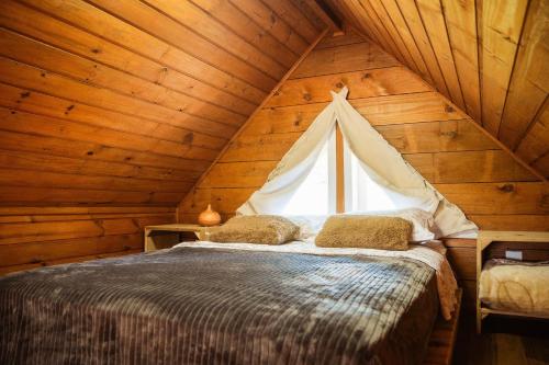 a bedroom with a bed in a wooden cabin at Recanto das Águas - Urubici - SC in Urubici