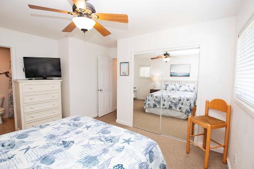 um quarto com uma cama e uma ventoinha de tecto em NH301, Driftwood Dreaming- Hot Tub, Oceanside, Close to Ocean! em Nags Head