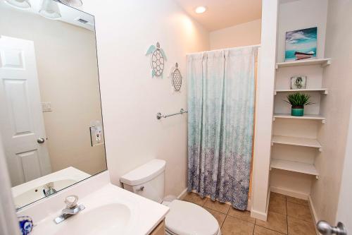 a bathroom with a toilet and a sink and a shower at NH301, Driftwood Dreaming- Hot Tub, Oceanside, Close to Ocean! in Nags Head