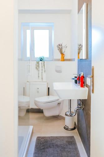 a bathroom with a white toilet and a sink at namastay! Stilvoll Wohnen im Herzen von Mannheim in Mannheim