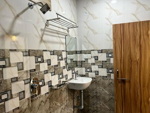 La salle de bains est pourvue d'un lavabo et d'un miroir. dans l'établissement Hotel Parvati Residency, à Sītāpur Mūāfi