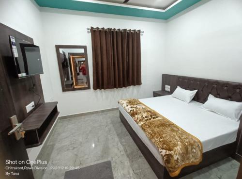 Sītāpur MūāfiにあるHotel Parvati Residencyのベッドルーム(ベッド1台、鏡、テレビ付)
