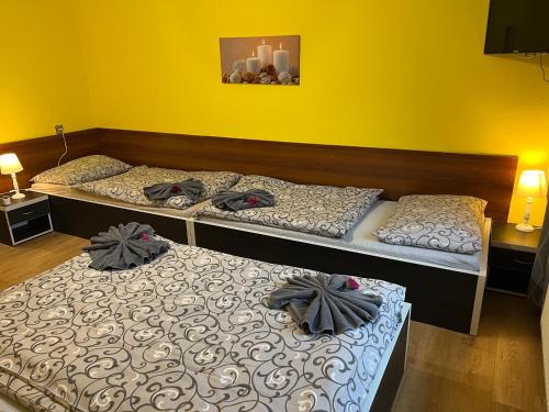 three beds in a room with yellow walls at Penzion na Lůkách in Horní Bečva
