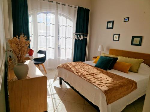 une chambre avec un grand lit avec des rideaux verts dans l'établissement la Cigalette, à Peypin