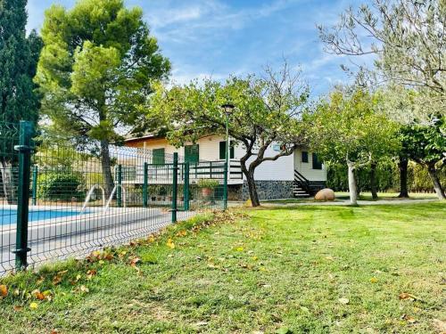 uma cerca em frente a uma casa com um quintal em Villa con piscina privada em Alacón