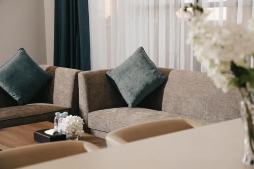 a living room with a brown couch with two pillows at Dream Residence Rawabi in Al Khobar