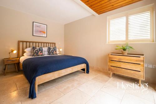a bedroom with a bed and a dresser and a window at The Lookout - 2 Bedroom Annex With Parking in Reading