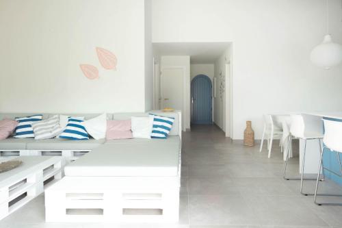 Sala de estar blanca con sofá y mesa en A Casa da Porta Azul, en Porches