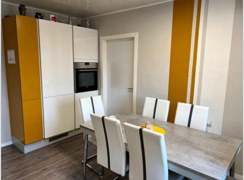 a kitchen with a table and white cabinets at Gemütliche Wohnung/ cozy apartment Niklasdorf in Niklasdorf