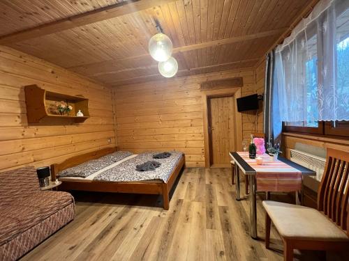 Penzion na Lůkách في هورني بيسافا: غرفة نوم بسرير وطاولة في غرفة