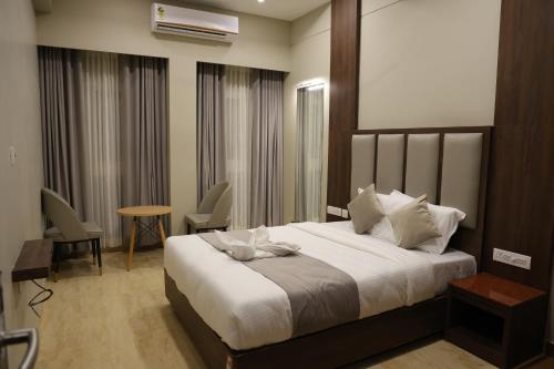 a bedroom with a bed and a table and chairs at Mount Grande "formerly known as Miot Grande" in Chennai