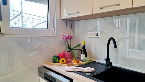 a kitchen counter with a sink and a bottle of wine at Apartman Leon in Rijeka