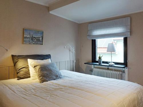 1 dormitorio con 1 cama blanca grande y ventana en Holiday home LYSEKIL IX, en Lysekil