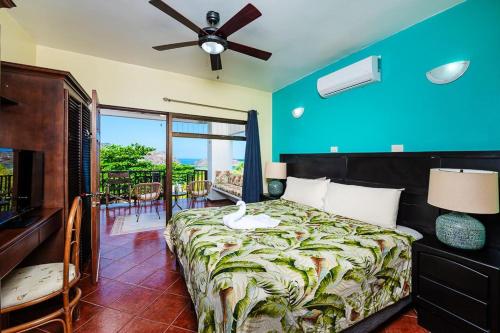 1 dormitorio con 1 cama con ventilador y balcón en Almendros 35 en Ocotal