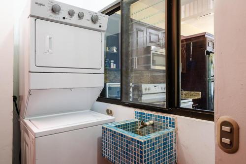 una pequeña cocina con nevera blanca y ventana en Almendros 35 en Ocotal
