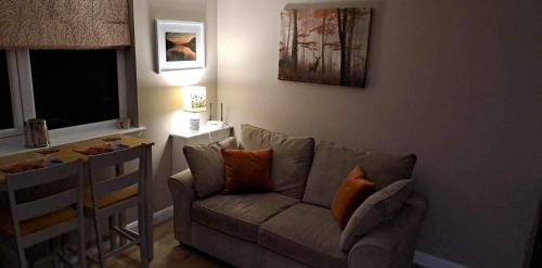 a living room with a couch and a table at Rowan Bank Retreat in Fort Augustus