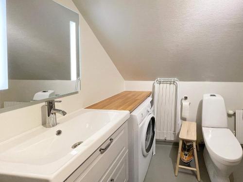 a bathroom with a sink and a washing machine at Holiday home SÖLVESBORG V in Sölvesborg