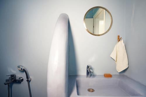 a white bathroom with a tub and a mirror at VILLA AMBROSIA in Khálara