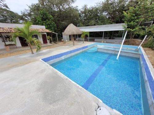a large blue swimming pool with a building in the background at Casa Pueblo Ocú in El Hatillo