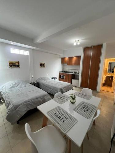 een slaapkamer met twee bedden en een tafel en stoelen bij Cálido dpto en pleno centro in Corrientes