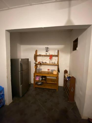 eine Küche mit einem Kühlschrank und einem Tisch darin in der Unterkunft Village Hostel in Nungwi